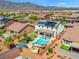 Aerial view of backyard featuring a pool, hot tub, covered patio, putting green, and desert landscaping at 8925 Kenzie Cove St, Las Vegas, NV 89131