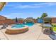 Beautiful backyard pool and spa featuring a rock waterfall, surrounded by a spacious patio for relaxation and enjoyment at 8925 Kenzie Cove St, Las Vegas, NV 89131