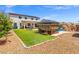 Lush backyard with a well-maintained lawn, gazebo, rock pool, and a backdrop of a two-story home at 8925 Kenzie Cove St, Las Vegas, NV 89131