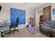 Cozy bedroom with wood flooring, a desk, a blue accent wall, and unique decorative touches at 8925 Kenzie Cove St, Las Vegas, NV 89131