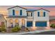 Charming two-story home with blue shutters, a tile roof, desert landscaping, and a two-car garage at 8925 Kenzie Cove St, Las Vegas, NV 89131