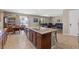Spacious kitchen with dark cabinets, stainless steel appliances, a large island, and an adjacent living room at 8925 Kenzie Cove St, Las Vegas, NV 89131
