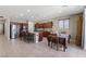 Open-concept kitchen with stainless steel appliances, granite island, dark wood cabinets, and an adjacent dining area at 8925 Kenzie Cove St, Las Vegas, NV 89131