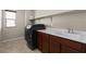 Laundry room featuring a modern washer and dryer, sink, and cabinet space at 8925 Kenzie Cove St, Las Vegas, NV 89131