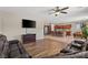 Open-concept living room with hardwood floors connecting to a kitchen with stainless appliances and seating at 8925 Kenzie Cove St, Las Vegas, NV 89131
