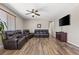 Spacious living room featuring wood floors, large windows with blinds, and comfortable leather seating at 8925 Kenzie Cove St, Las Vegas, NV 89131