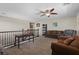 Inviting loft area with carpet, plenty of seating, a desk, and wrought iron railing overlooking below at 8925 Kenzie Cove St, Las Vegas, NV 89131