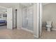 Well-lit main bathroom with glass enclosed shower and toilet located near the main bedroom at 8925 Kenzie Cove St, Las Vegas, NV 89131