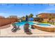 Backyard featuring a refreshing swimming pool and hot tub with lounge chairs at 8925 Kenzie Cove St, Las Vegas, NV 89131