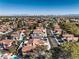 Wide aerial shot shows a community with uniform roofs, mature trees, and a glimpse of the distant cityscape at 8932 Beach Front Dr, Las Vegas, NV 89117