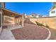 Spacious backyard featuring a covered patio with brick and gravel landscaping, enclosed by a block wall at 8932 Beach Front Dr, Las Vegas, NV 89117