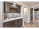 Stylish bar area features dark wood cabinets, quartz countertop, wine rack, and mosaic tile backsplash at 8932 Beach Front Dr, Las Vegas, NV 89117