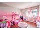 A pink bedroom featuring hardwood floors, decorated with a princess theme and lots of toys at 8932 Beach Front Dr, Las Vegas, NV 89117