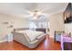 Bright main bedroom boasts wood floors, ceiling fan, and dresser, with ample natural light at 8932 Beach Front Dr, Las Vegas, NV 89117