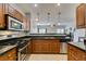 This kitchen boasts stainless steel appliances, wooden cabinetry, backsplash, and a granite countertop at 9362 Straw Hays St # 103, Las Vegas, NV 89178