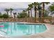 Community swimming pool surrounded by palm trees and lounge chairs creates a relaxing oasis for residents at 9362 Straw Hays St # 103, Las Vegas, NV 89178
