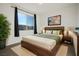 Cozy bedroom featuring a wooden bed frame, bedside tables, and a large window at 9476 Lunar Phase St, Las Vegas, NV 89143