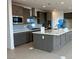 Beautiful kitchen with an island, gray cabinets, and stainless steel appliances at 9476 Lunar Phase St, Las Vegas, NV 89143