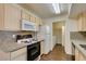 Galley kitchen with gas range, white appliances, and granite countertops at 950 Seven Hills Dr # 524, Henderson, NV 89052
