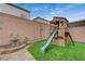 A backyard showcases a play structure with a slide and a charming decorative fountain at 9835 Fox Estate St, Las Vegas, NV 89141