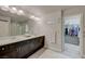 Bathroom features dual sinks, dark cabinets, and a door that leads into a walk-in closet at 9835 Fox Estate St, Las Vegas, NV 89141