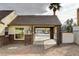 View of gated carport and tan exterior with brick base, dark roof, and minimal landscaping at 1017 E Oakey Blvd, Las Vegas, NV 89104