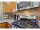 Modern kitchen with stainless steel appliances, granite countertops, and tiled backsplash at 10203 Arlington Abby St, Las Vegas, NV 89183