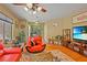 Bright living room featuring hardwood floors, a large window, and comfortable red seating at 10203 Arlington Abby St, Las Vegas, NV 89183