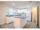 Bright kitchen featuring white cabinetry, tiled floors, island, and appliances, all bathed in natural light at 1136 Paradise Garden Dr, Henderson, NV 89002
