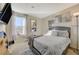 Comfortable bedroom with a gray bed, decorative pillows, and a fur rug, lit by a window and floor lamp at 1317 Hopespring Loop Ave, North Las Vegas, NV 89084