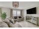 Bright living room with stylish sofas, a mirrored console, and a large TV for entertainment at 1317 Hopespring Loop Ave, North Las Vegas, NV 89084