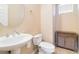 Elegant half bath features pedestal sink, toilet, and storage cabinet at 174 Augusta Course Ave, Las Vegas, NV 89148