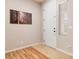Clean entryway featuring tile and wood flooring, complemented by modern artwork and a bright white door at 174 Augusta Course Ave, Las Vegas, NV 89148