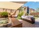 Backyard with a hot tub, outdoor seating, and mature landscaping under a shade at 174 Augusta Course Ave, Las Vegas, NV 89148
