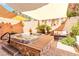 Backyard with a built-in hot tub, lounge seating, brick accents, and shade at 174 Augusta Course Ave, Las Vegas, NV 89148