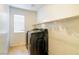 Modern laundry room with sleek, black, high-efficiency washer and dryer, and overhead shelving at 174 Augusta Course Ave, Las Vegas, NV 89148