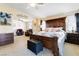 Open-concept main bedroom with a sitting area, features a decorative wooden bed frame, and neutral color palette at 174 Augusta Course Ave, Las Vegas, NV 89148