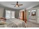 Bright bedroom boasts a ceiling fan, a four-poster bed, and an ensuite bathroom at 209 Tamarack Dr, Henderson, NV 89002