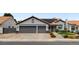 Charming single-story home featuring a two-car garage, tiled roof, desert landscaping, and solar panels at 209 Tamarack Dr, Henderson, NV 89002