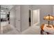 Bright hallway with white tile flooring leads to a living area and features neutral walls and modern fixtures at 209 Tamarack Dr, Henderson, NV 89002