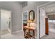 Hallway view with white tile floor, table, lamp and view into the main bedroom at 209 Tamarack Dr, Henderson, NV 89002