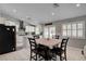 Bright kitchen with white cabinets, tiled floors, black appliances, and a dining area with seating at 209 Tamarack Dr, Henderson, NV 89002