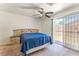 Bedroom features a blue comforter, ceiling fan, and sliding door to the patio at 2104 Kendall Hill Ave, Las Vegas, NV 89106