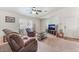 Inviting living room featuring neutral carpet, ceiling fan, and comfortable seating arrangement at 2104 Kendall Hill Ave, Las Vegas, NV 89106