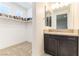 Modern bathroom features a sleek vanity with dark wood cabinets and storage space next to an open closet at 211 E Kimberly Dr, Henderson, NV 89015