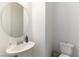 Small powder room featuring a sleek round mirror, white vanity, and modern toilet for guests' convenience at 211 E Kimberly Dr, Henderson, NV 89015