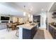 Open-concept kitchen and living area with island seating, stainless steel appliances, and modern finishes at 211 E Kimberly Dr, Henderson, NV 89015