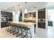 Well-lit kitchen boasts a long island with seating, stainless appliances, and sleek, dark cabinetry at 211 E Kimberly Dr, Henderson, NV 89015