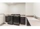 Well-equipped laundry room with sleek, new appliances and ample counter space with sink and storage at 211 E Kimberly Dr, Henderson, NV 89015