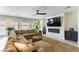 Cozy living room featuring a large sectional sofa, modern fireplace, and abundant natural light from the windows at 211 E Kimberly Dr, Henderson, NV 89015